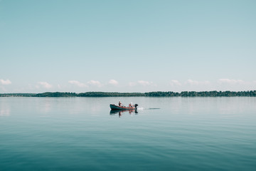 Fototapeta na wymiar Two fishermen in a small boat on a calm lake