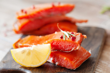 Smoked salmon fillet with pepper, salt, rosemary and lemon and rosemary on wooden table