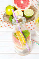 Infused flavored water with fresh fruits on white wooden background.Refreshing summer homemade  detox water