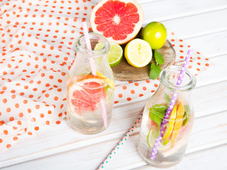 Infused flavored water with fresh fruits on white wooden background.Refreshing summer homemade  detox water
