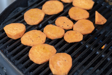 Top view on sweet potatoe slices on the gas grill