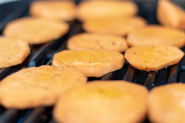Some sweet potatoe slices on a metal grillage in the garden 