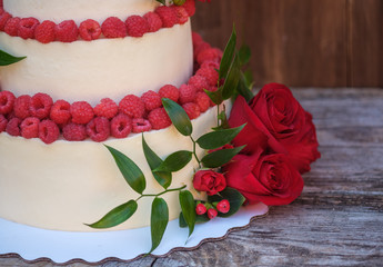 beautiful wedding cake with red rose and fresh raspberries
