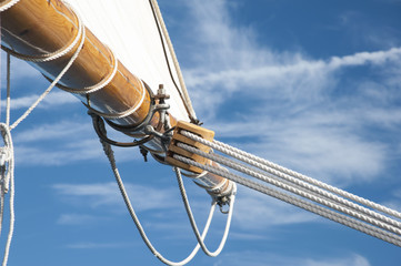Lines Hold Sail to Wooden Boom on Old Schooner Vessel