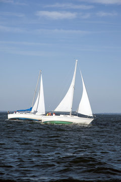 A Pair of Sailboats Next to One Aother Leaning at Full Sail in Maine