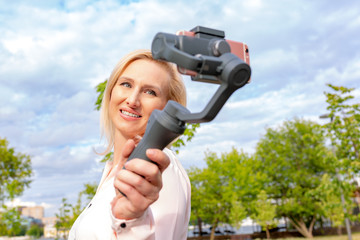 the girl with the phone on the stabilizer leads the videoblog. She takes himself to the camera Smartphone