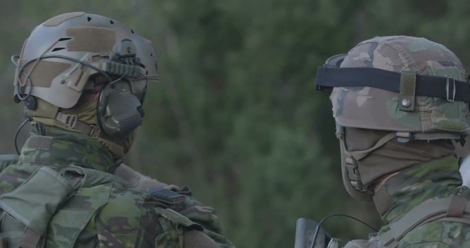 Special forces soldiers in a full combat uniform on a post in the woods