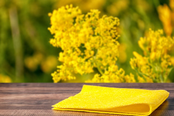 yellow napkin on a table in the background of yellow flowers