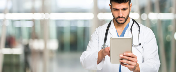 Doctor using his tablet. Large copy-space