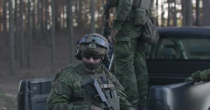 Special forces soldiers in a full combat uniform on a post in the woods