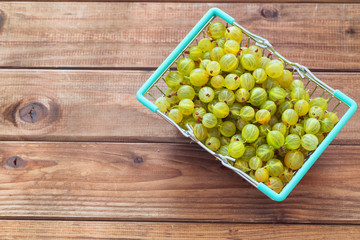 gooseberries in a shopping basket on a wooden table