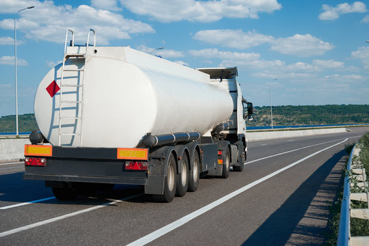 Fuel Truck Rides On Highway, White Blank Cistern For Oil, Rear View, One Object On Road