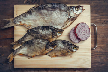 Dried fish on a wooden cutting board.