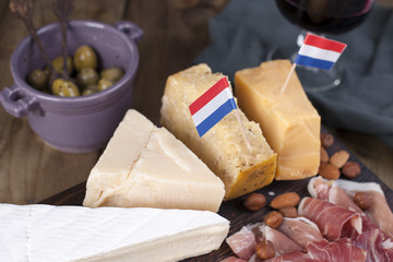 Assorted cheese, meat, wine in a glass and olives. Delicious Dutch snack for a party. View from above. Copy space.