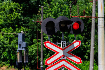 Railroad crossing sign with blinking red lights of semaphore