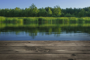 Wooden table from boards on landscape of lake background