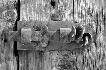 Old rusty textured latch on a wooden door