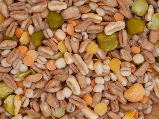 Assorted grains and pulses mix full background, top view. Winter food includes split peas, red and yellow lentils, pearl barley, kamut, spelt.