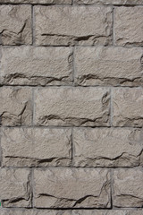The wall of gray stones in the form of bricks. Background. Photo vertical format