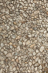 Pebble stone floor tile seamless background. Cement mixed gravel pebble stone floor texture. Wet round pebble stone rock floor in dramatic lighting.