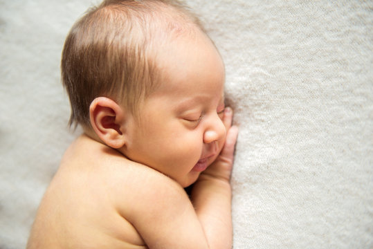 Newborn baby sleeping peacefully naked