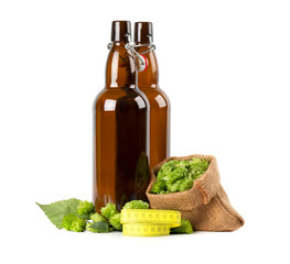 Glass bottles for kraft beer with fresh green branch of hops and yellow measuring tape, isolated on white background. Diet concept.