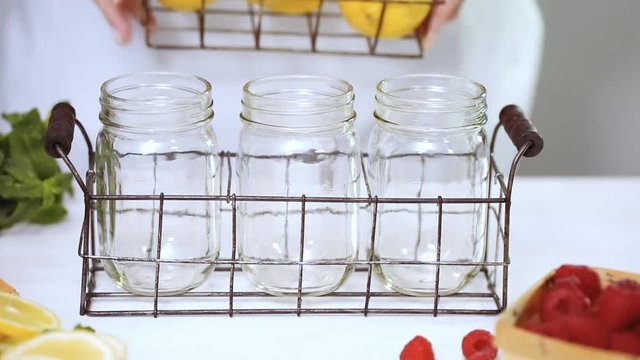 Pouring raspberry lemonade in drinking mason jars