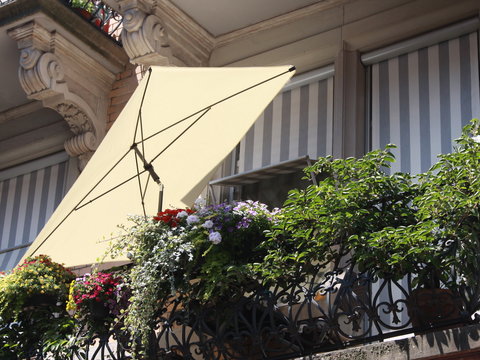 white sun blind on a balcony with plants