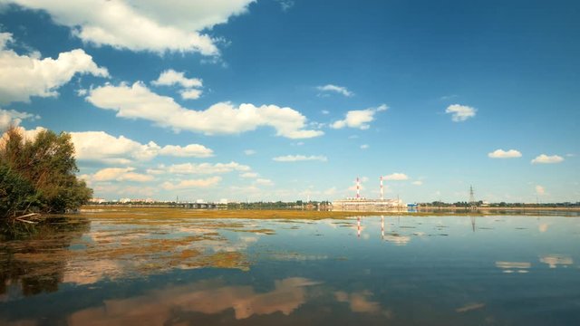 Electrical power plant and clouds reflected in river, toned