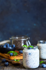 Homemade yogurt with sesena chia and blueberries that have a dark background. Proper nutrition.