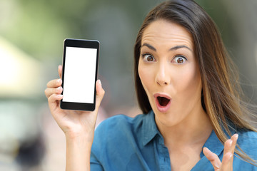 Amazed woman showing a blank smart phone screen