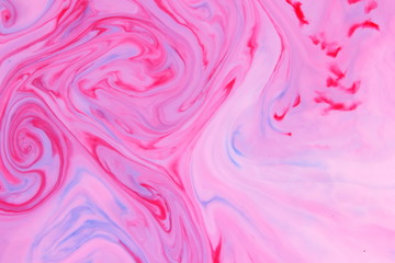 Pink blue abstract background, pink stains on the liquid, multi-colored pattern, food colors in the milk, color texture on the water, preparation for the designer