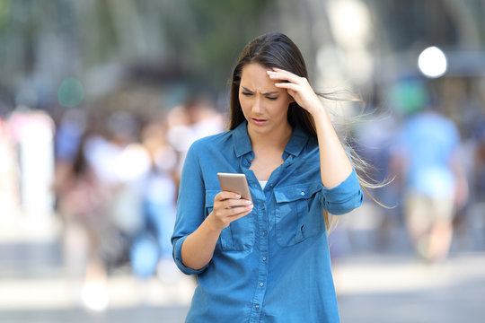 Worried woman checking smart phone messages