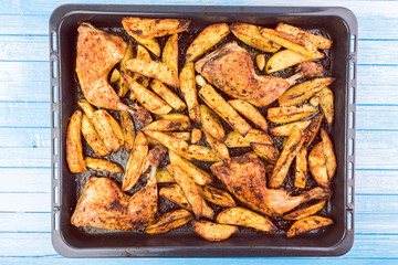 Crunchy Chicken Legs And Potatoes With Spicy Seasoning  And Garlic Top View Dish