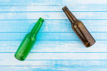 Green And Brown Empty Beer Bottles On Blue White Painted Wood Background Summer Concept High...