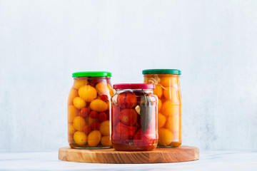 Harvest of red and yellow tomatoes, closed in cans for preservation and fermentation. Autumn preparations for wintering