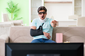Man with neck and arm injury watching tv