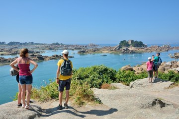 Obraz na płótnie Canvas Des touristes qui admirent la magnifique côte de granit rose à Ploumanach en Bretagne. France