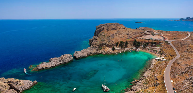 Aerial birds eye view drone photo Saint Paul bay near village Lindos, Rhodes island, Dodecanese, Greece. Sunny panorama with lagoon and clear blue water. Famous tourist destination in South Europe