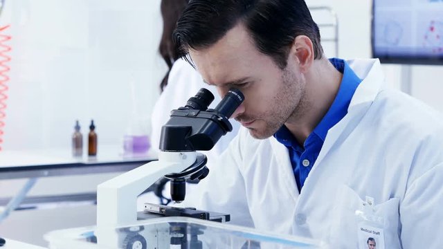 Male Scientist looking inside microscope at lab. People with science concept. 4K Resolution.