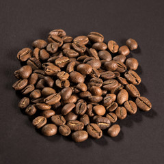 Pile of coffee beans on a black paper background