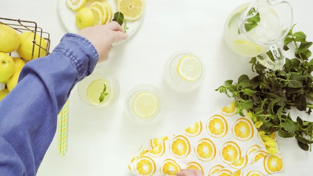 Step by step. Garnishing traditional fresh lemonade with lemon slices and mint