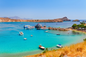 Fototapeta premium Sea skyview landscape photo Lindos bay and sea coast on Rhodes island, Dodecanese, Greece. Panorama with nice sand beach and clear blue water. Famous tourist destination in South Europe