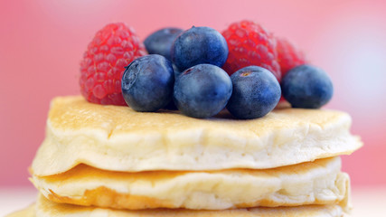 Stack of pancakes with raspberries, blueberries macro closeup.