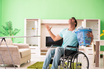 Disabled man on wheelchair doing laundry