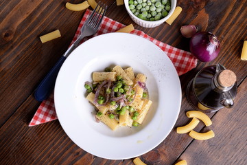 Plate with tortiglioni pasta onion and peas  