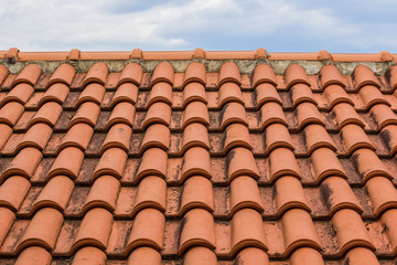 shingles red house roof foreground texture and gray cloudy sky background concept with empty space for copy or text