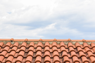 shingles red house roof foreground texture and gray cloudy sky background concept with empty space for copy or text