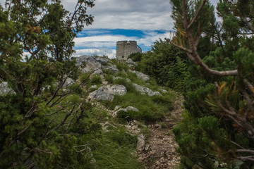 Fototapeta na wymiar soft focus old medieval tower on top of high mountain nature landscape concept in colorful summer gray rainy day time 