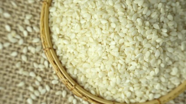 Rotating of white sesame seeds, close-up, top view, 4K